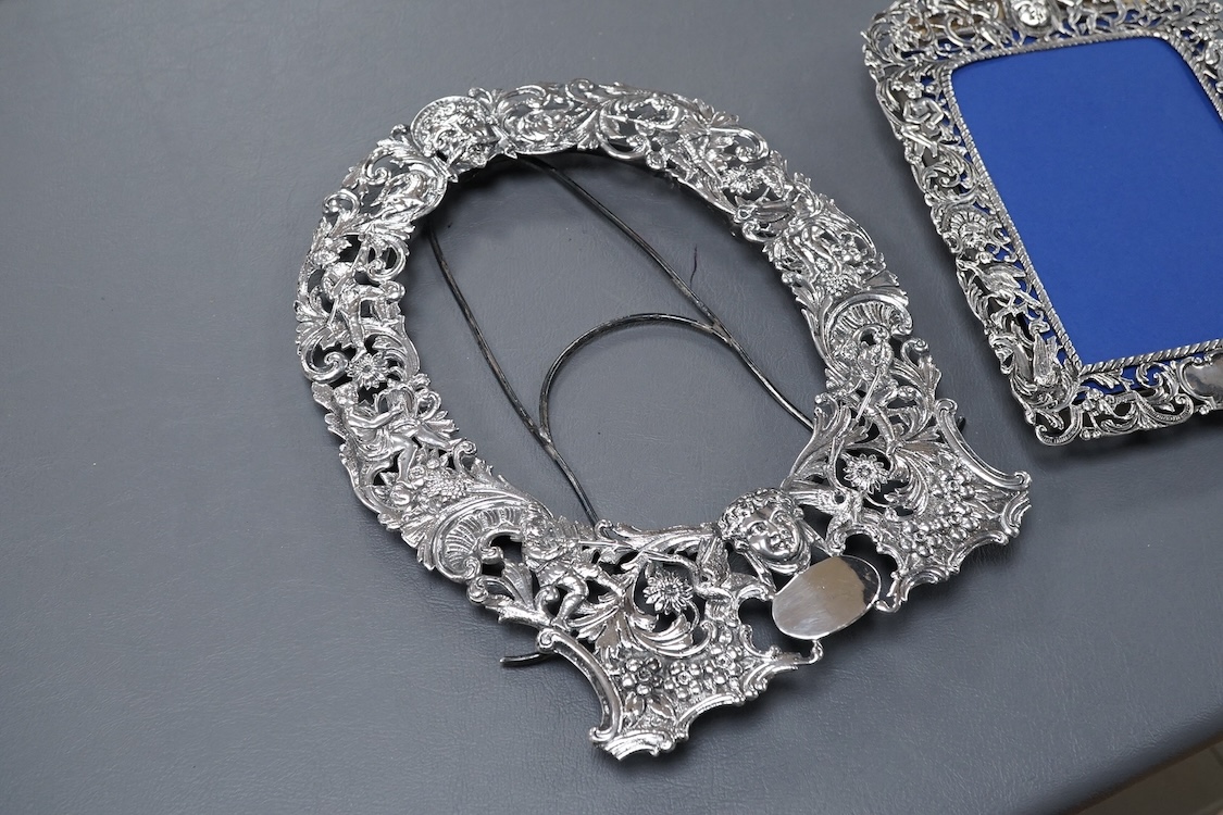 A late Victorian German Hanau silver photograph frame, pierced and decorated with mask, scrolls, figures and animals, import marks for Thomas Glaser, London, 1893, 23.7cm, gross weight 8.7oz, together with one other smal